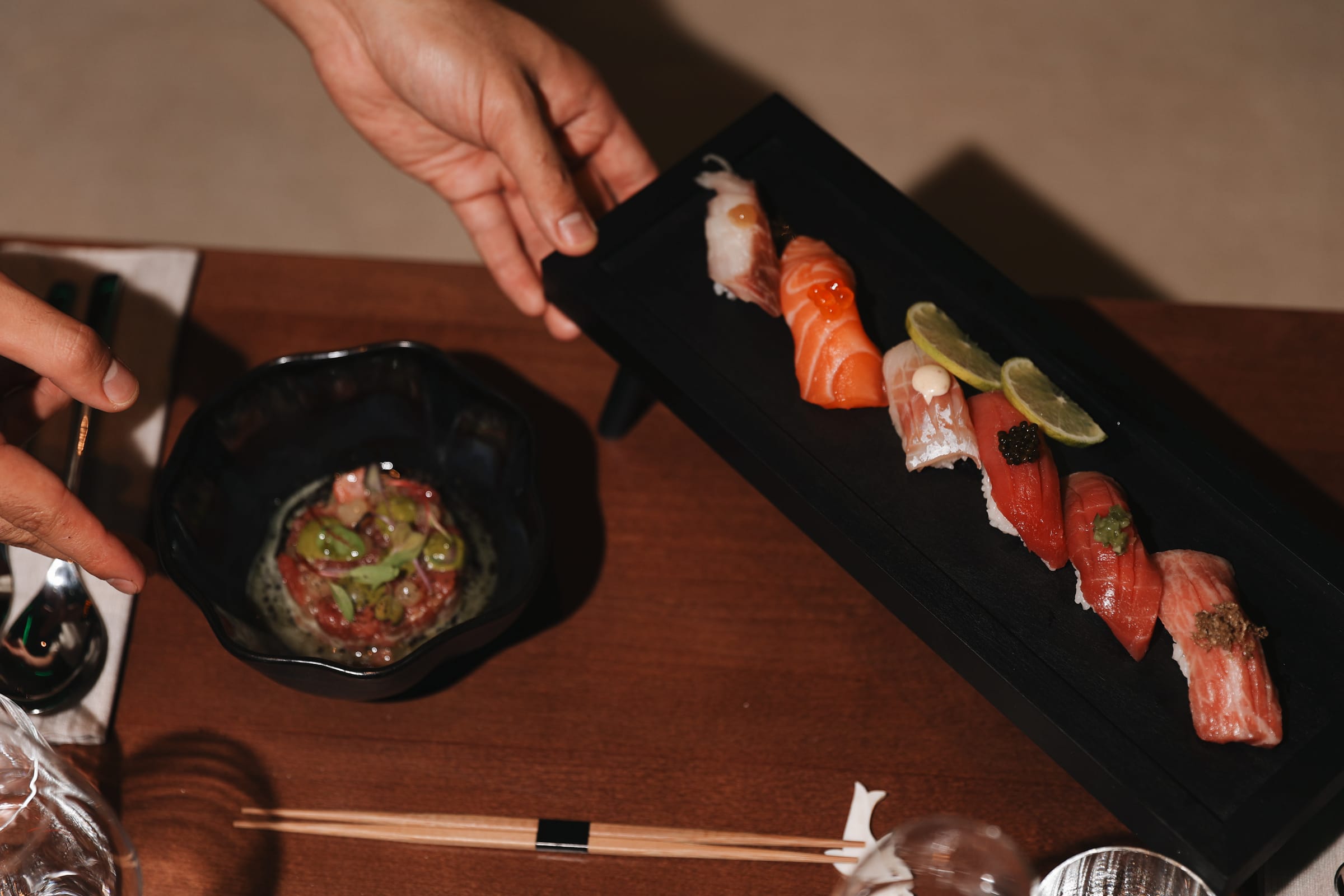 Nigiri-Platte und Tatar werden an den Tisch gebracht