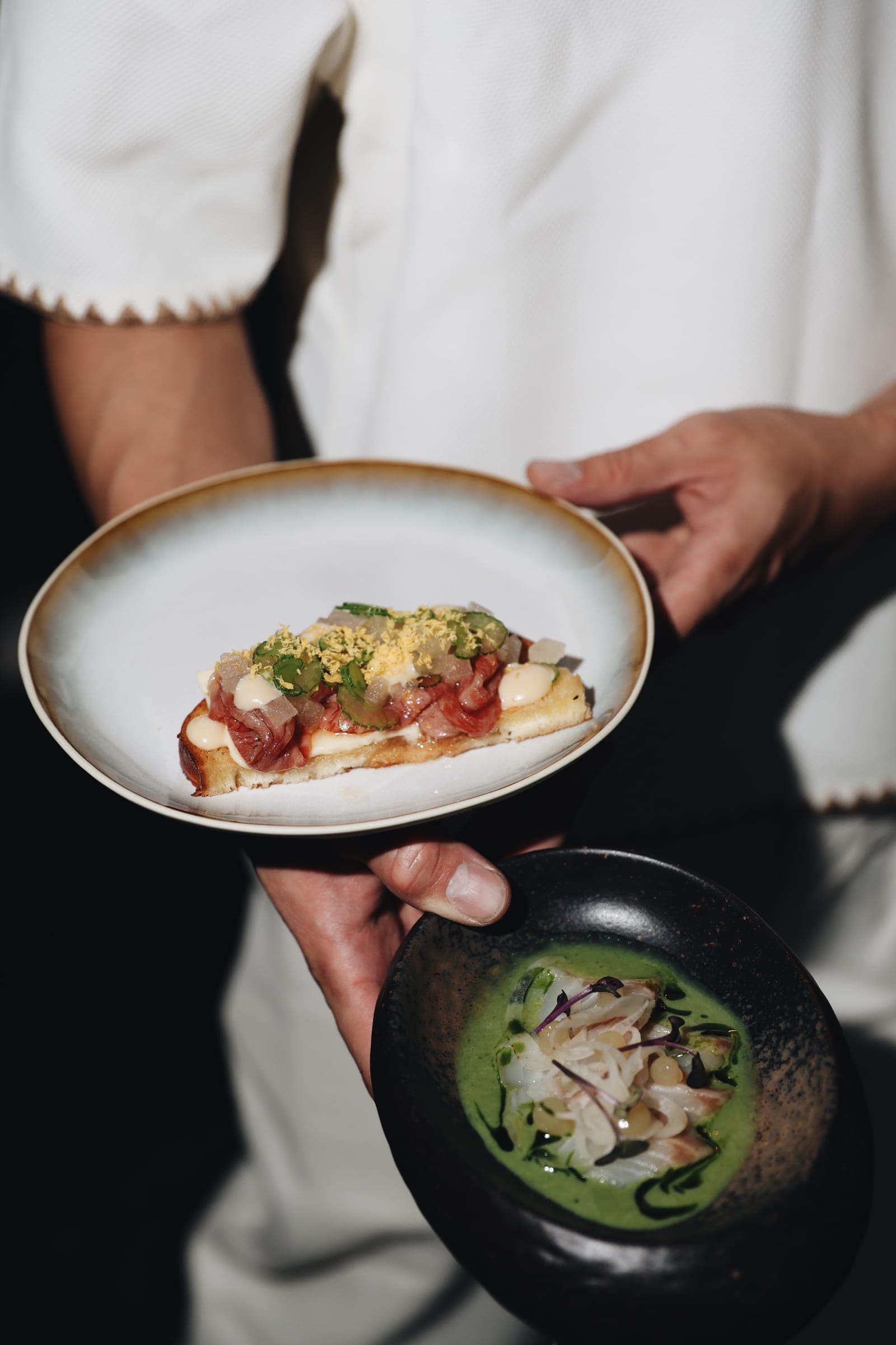 Service trägt Tuna Tataki und Gyoza an den Tisch